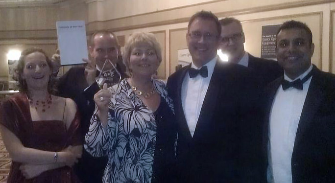 A group of OutsideClinic employees with an award.