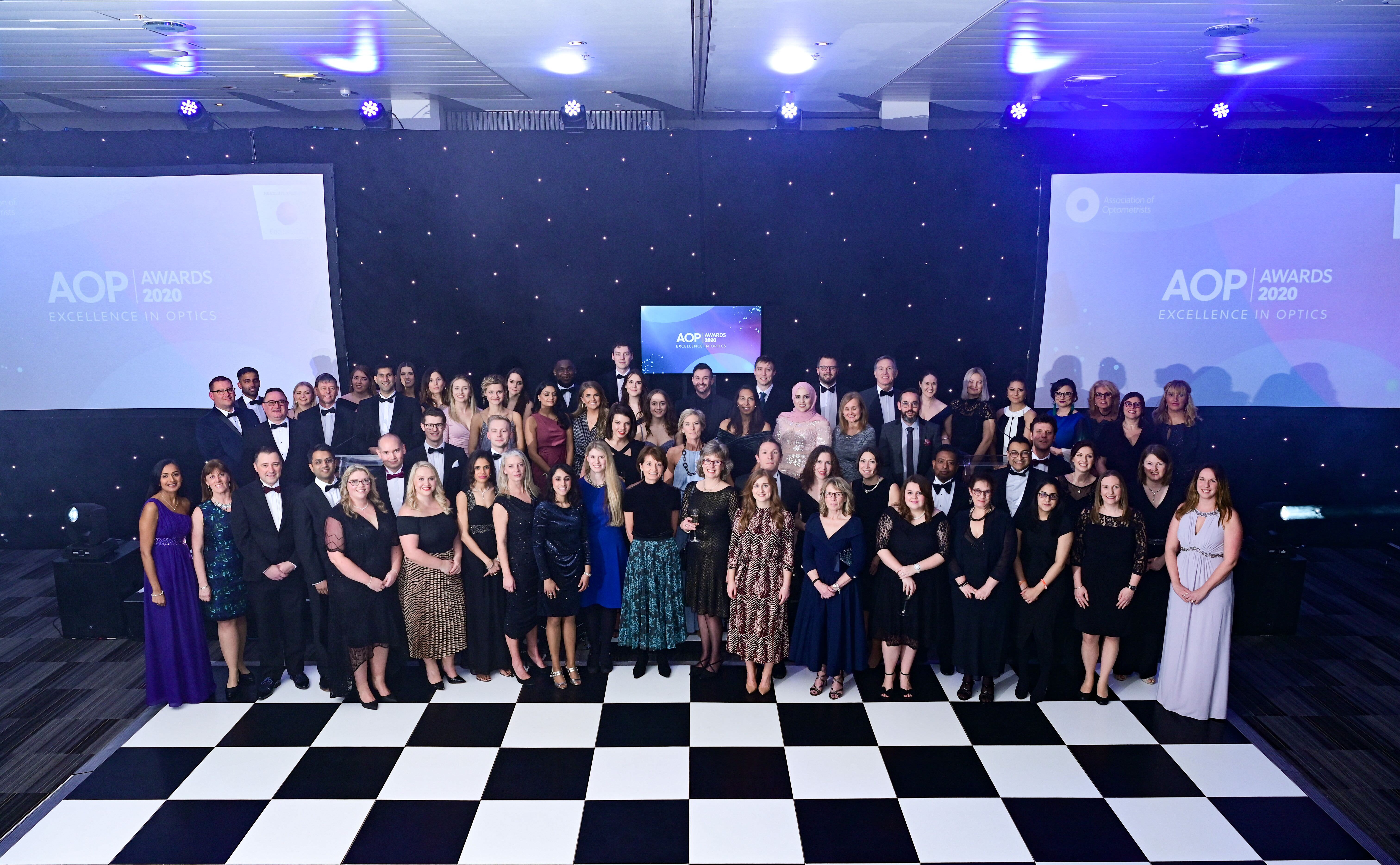 AOP Awards. A group of people in fancy clothing standing on a checked dancefloor.