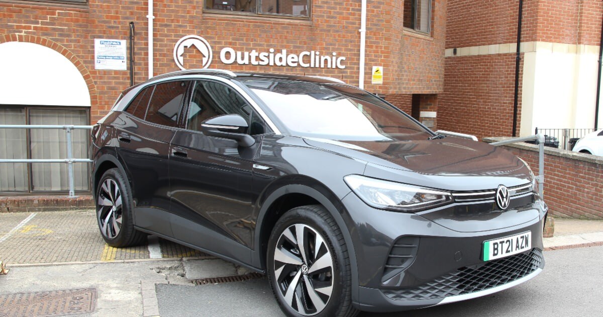 An image of an electric car in front of an OutsideClinic logo.