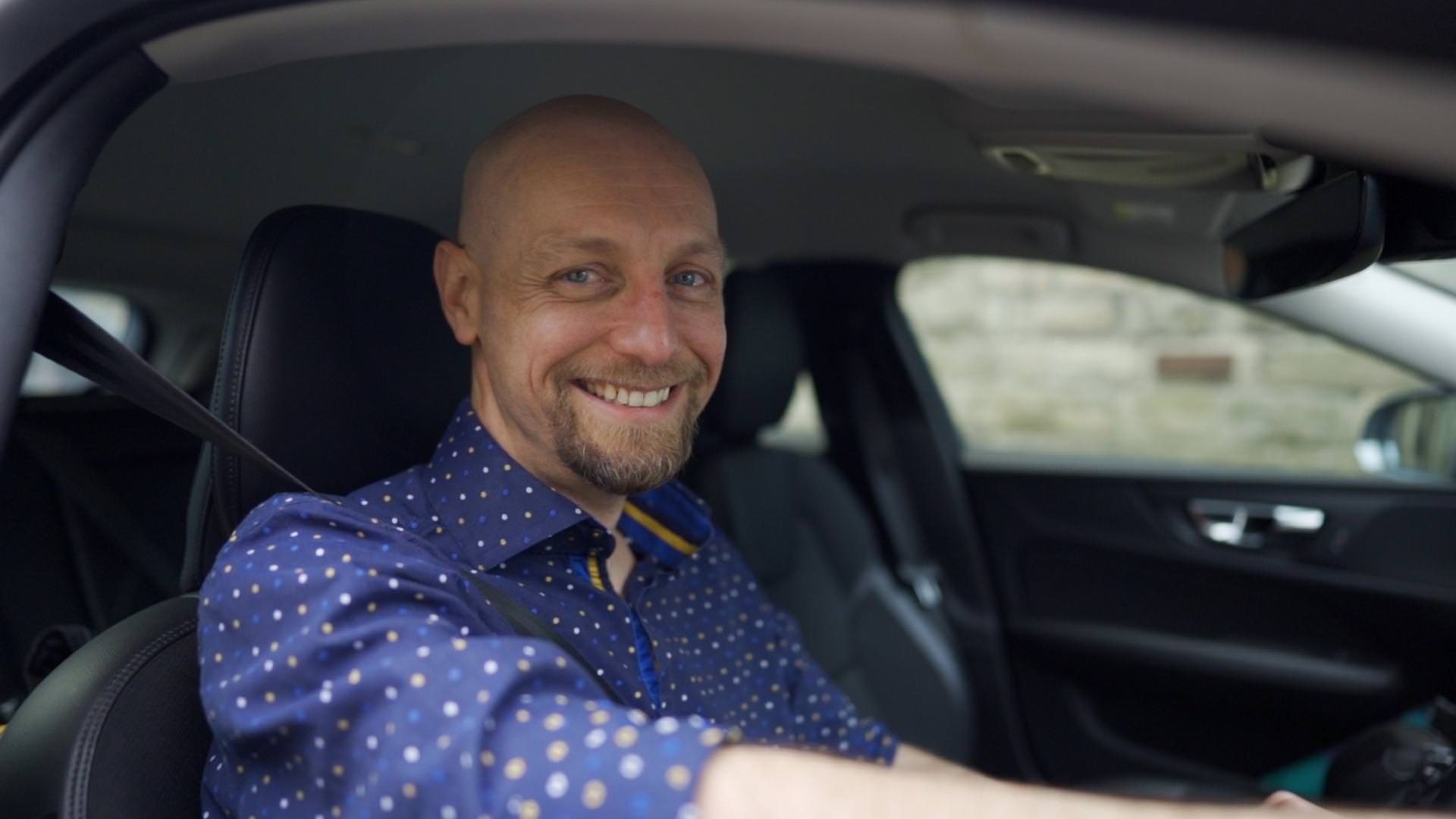 A man sitting in the driver's seat of a car.
