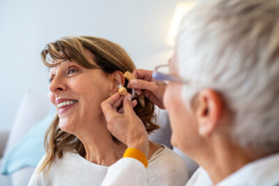 A woman having her hearing aids fitted by an audiologist.