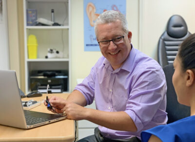 A man speaking to a woman in an office setting.