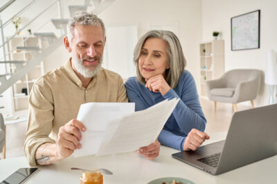 An elderly couple reading a sheet of paper