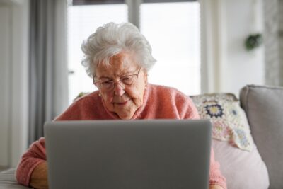 An elderly lady on her laptop doing some online shopping
