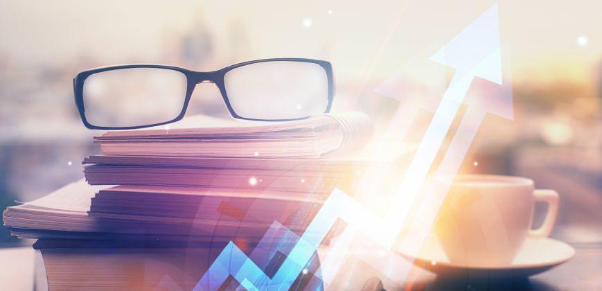 A pair of glasses on top of a pile of books with a stocks arrow embedded on top.