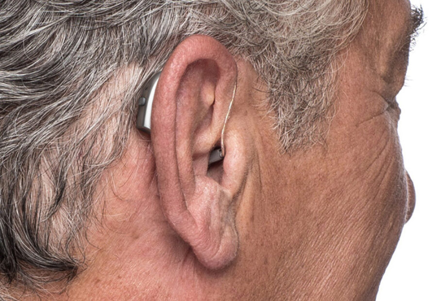 Back view of a RIC (Receiver In Canal) hearing aid being worn