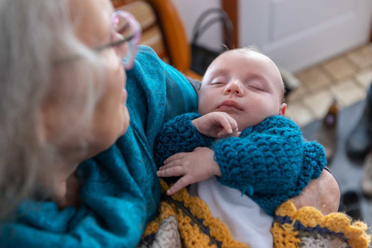 An elderly woman holding a baby.