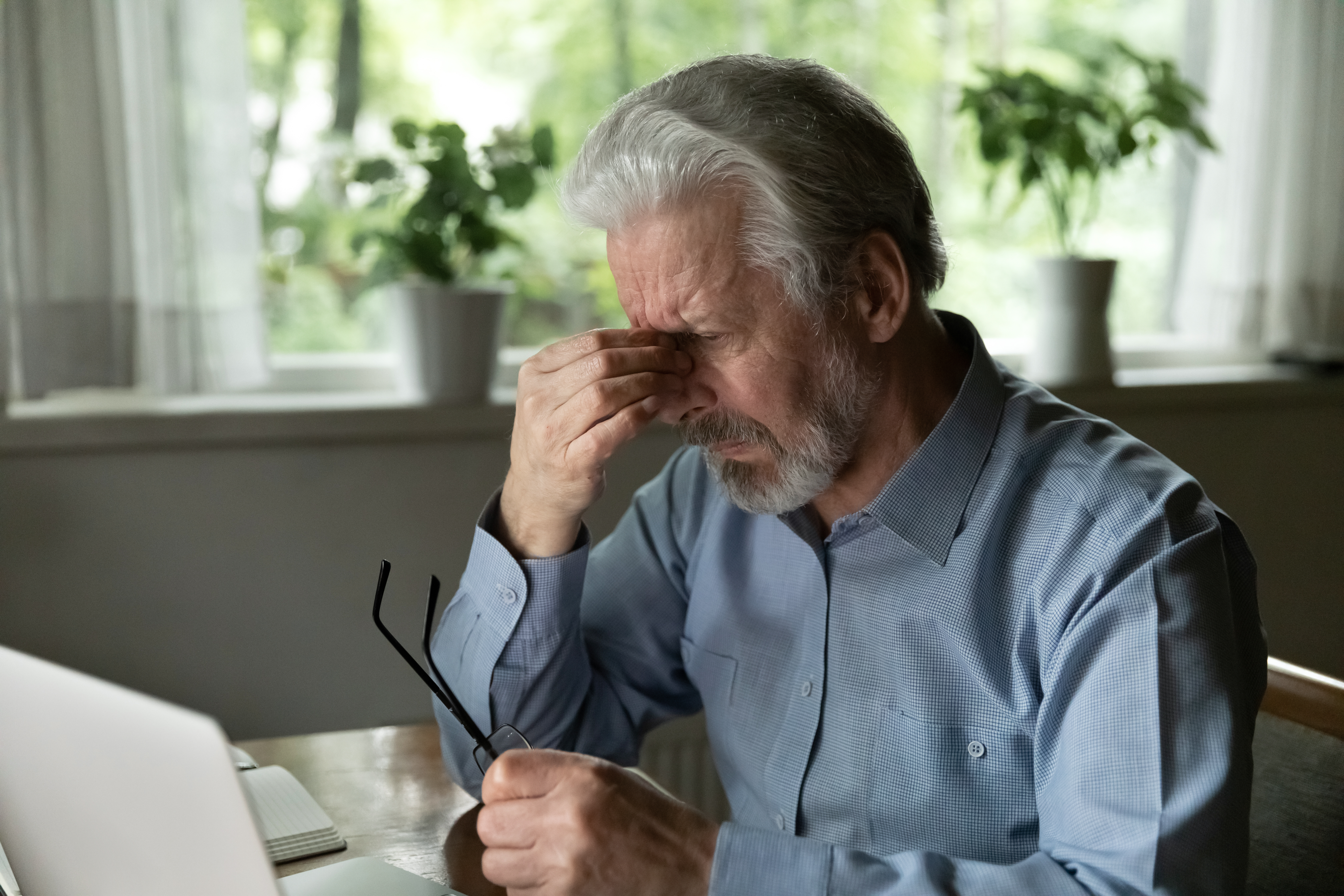A man pressing on his eyes in discomfort.